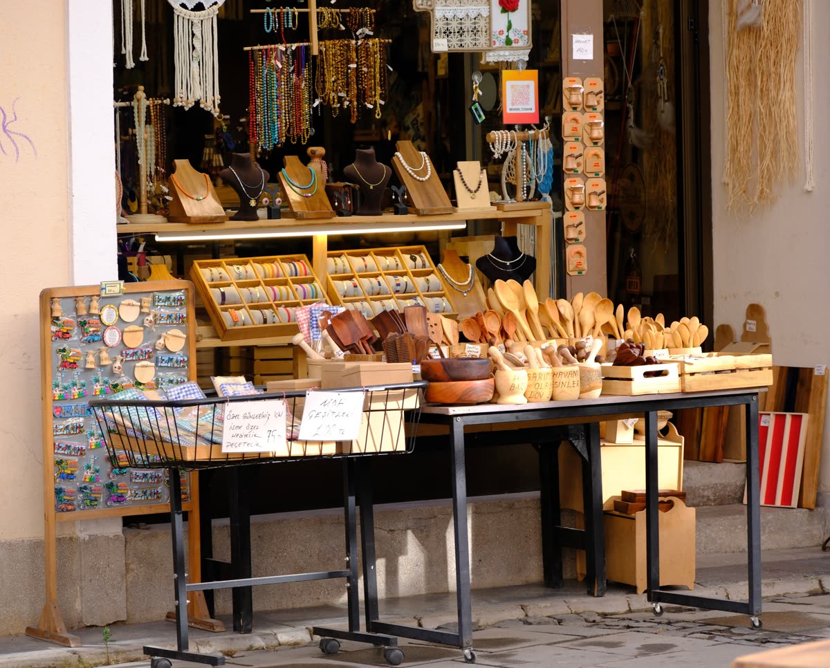 Banco di una bottega artigiana con oggetti in legno e bigiotteria esposti in strada