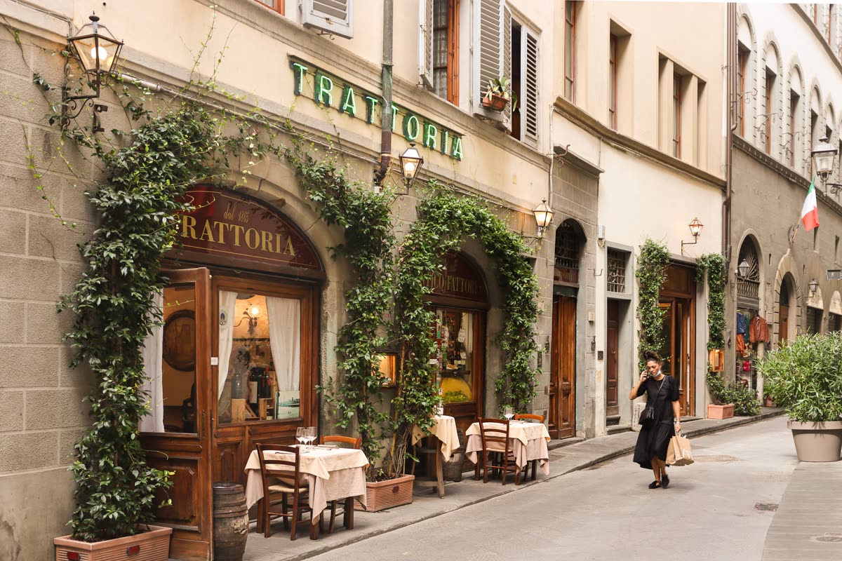 Trattoria storica affacciata su una via del centro, con tavoli apparecchiati all'esterno